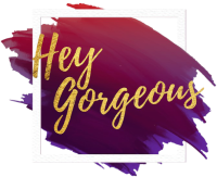 Gold text 'Hey Gorgeous' on a red and purple abstract background