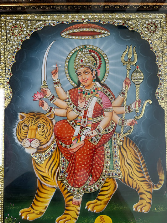 Close-up of large Durga Maa artwork showing gold leaf detailing