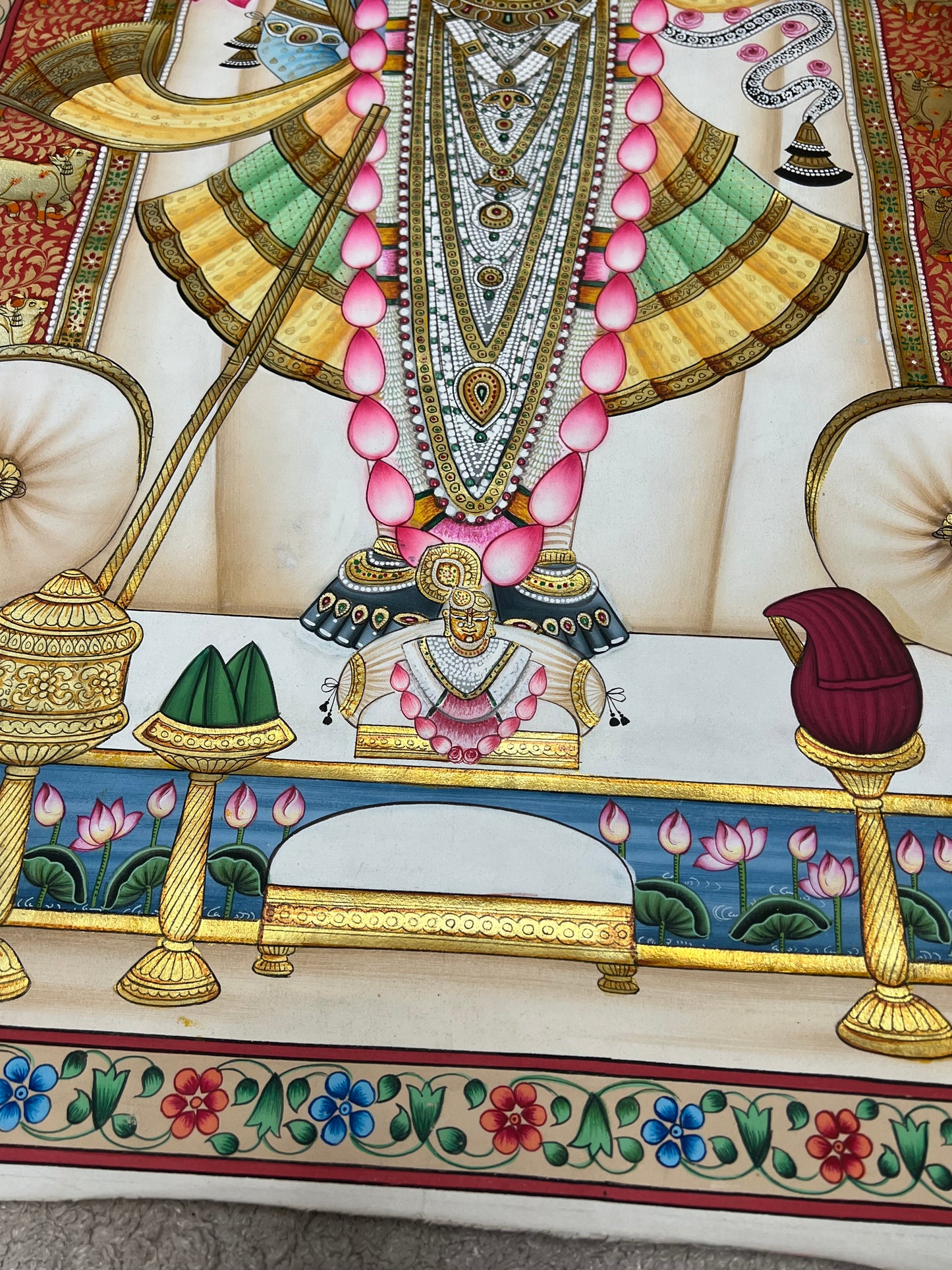 Close-up of Shreenathji Pichwai artwork showing gold leaf detailing and intricate brushwork