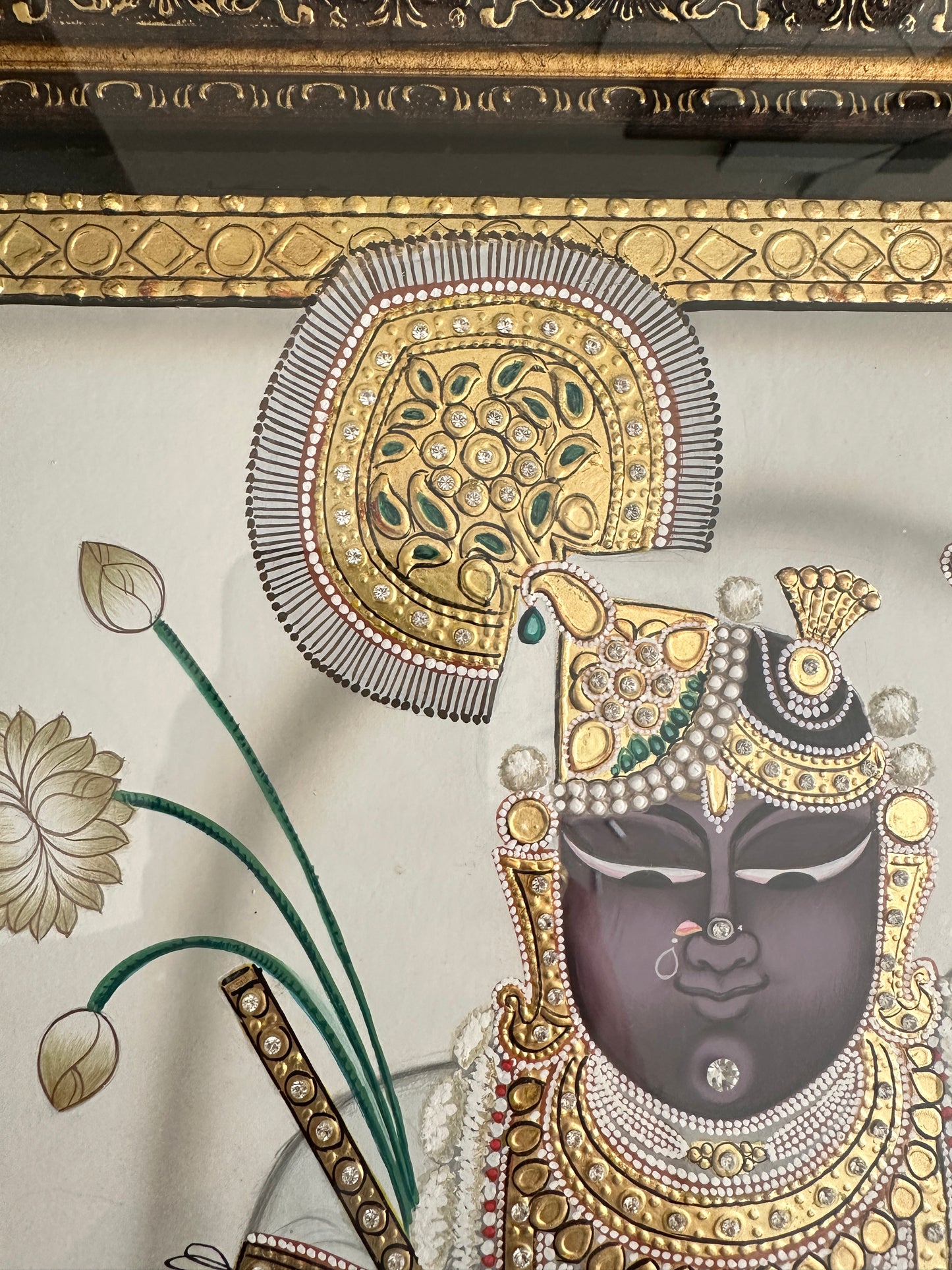 Close-up of Shreenathji artwork showing pearl and emerald detailing