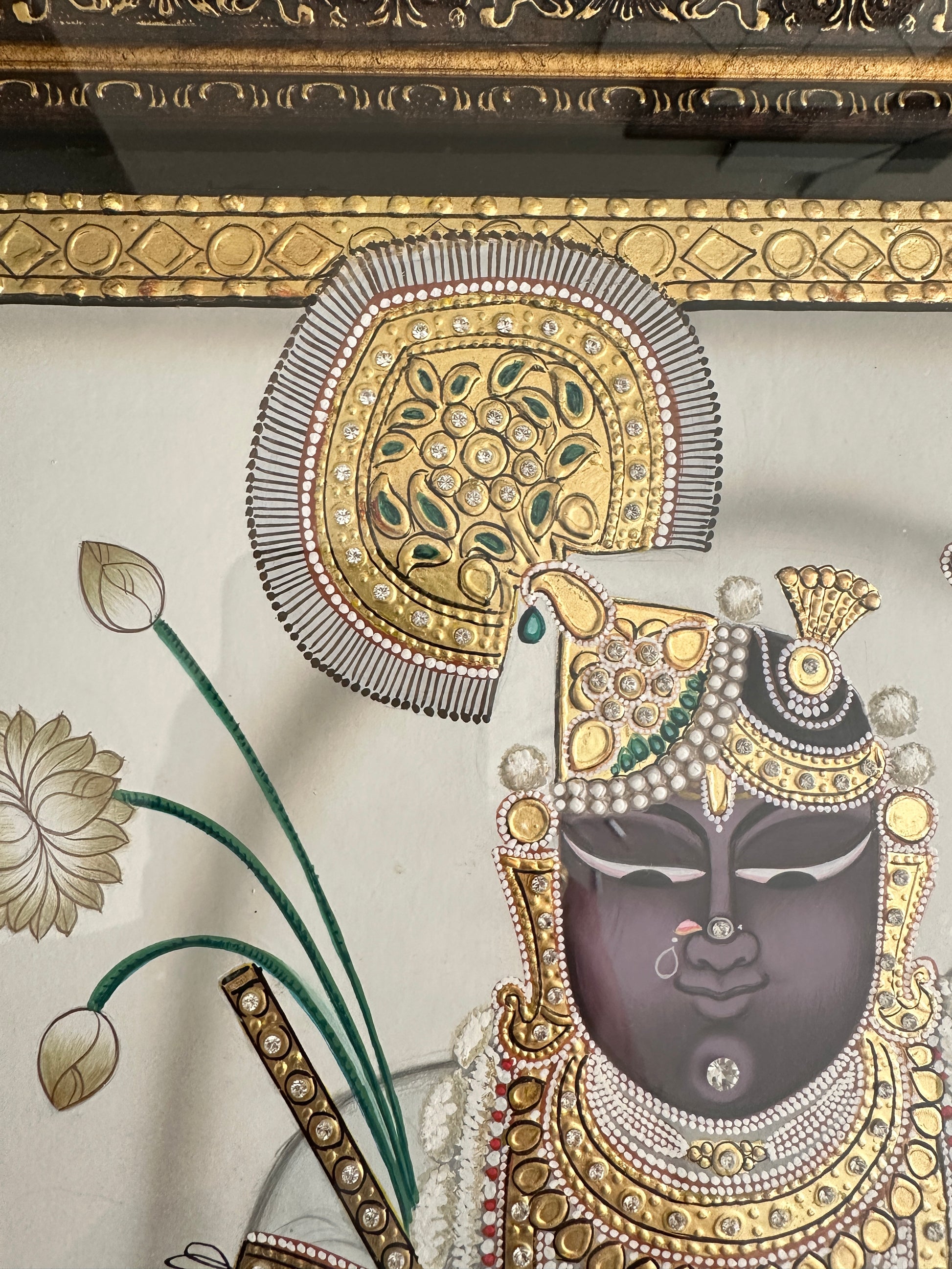 Close-up of Shreenathji artwork showing pearl and emerald detailing