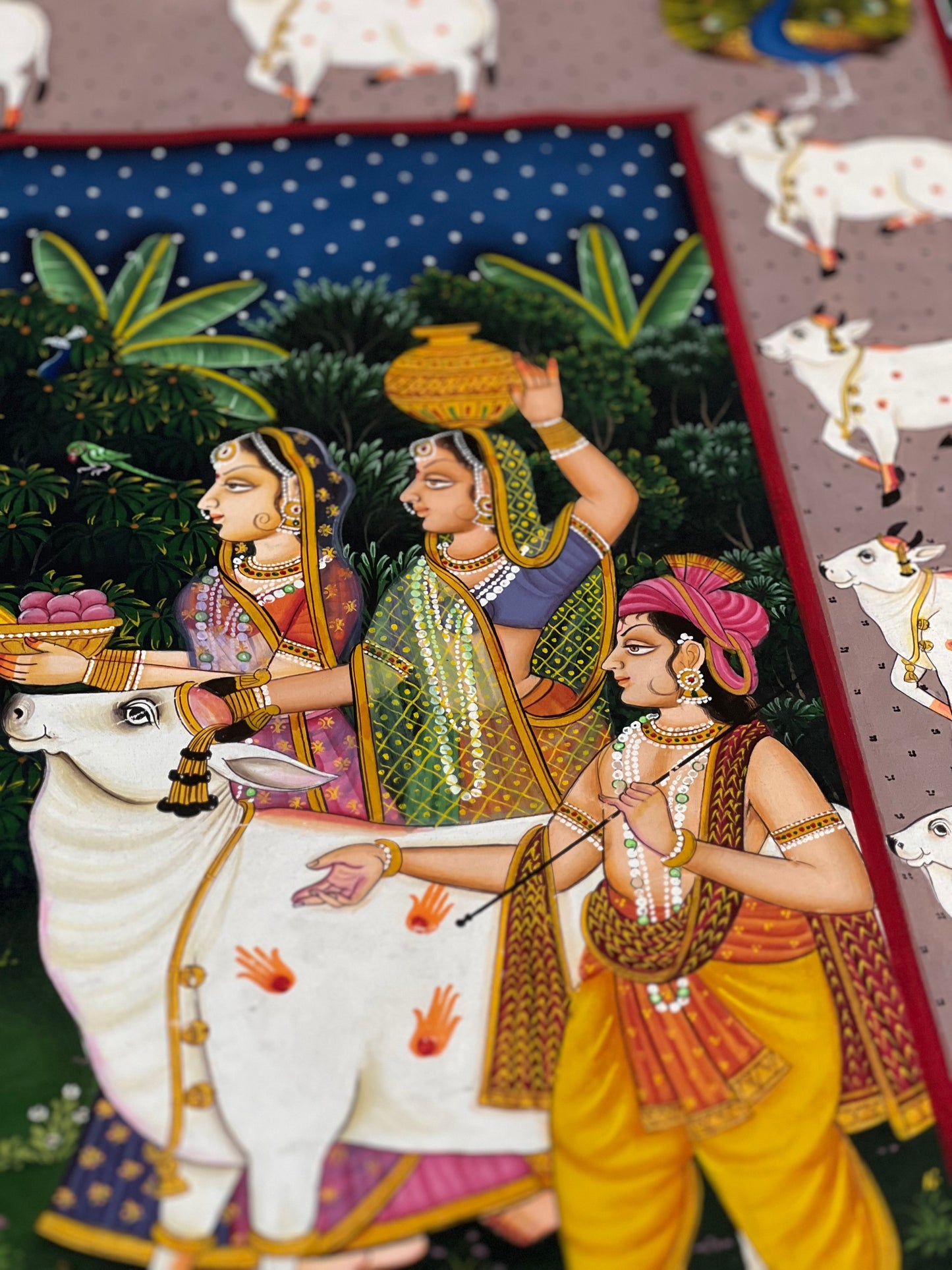 Close-up of handpainted Pichwai artwork showing intricate brushwork and traditional detailing