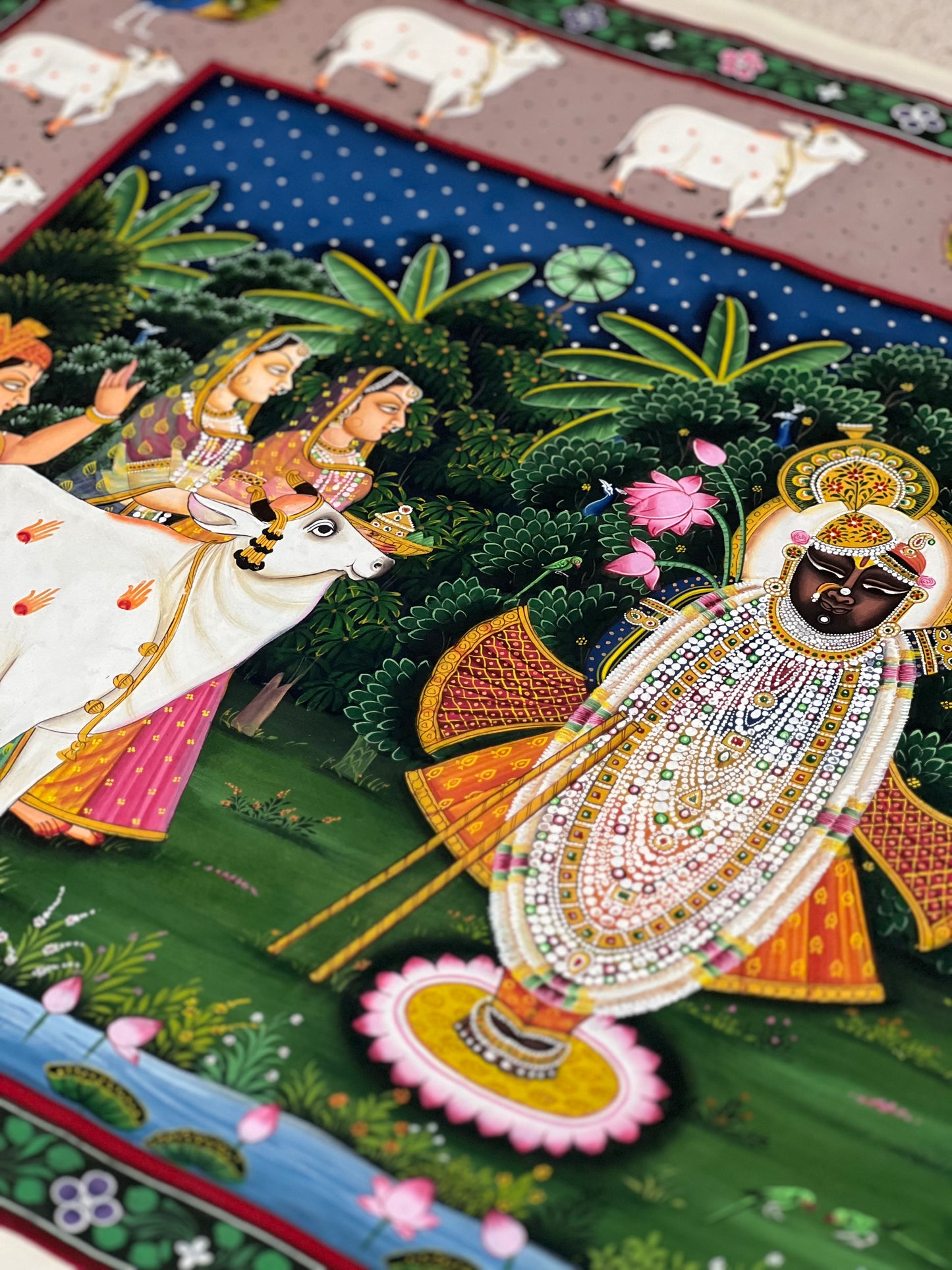 Close-up of handpainted Pichwai artwork showing intricate brushwork and traditional detailing
