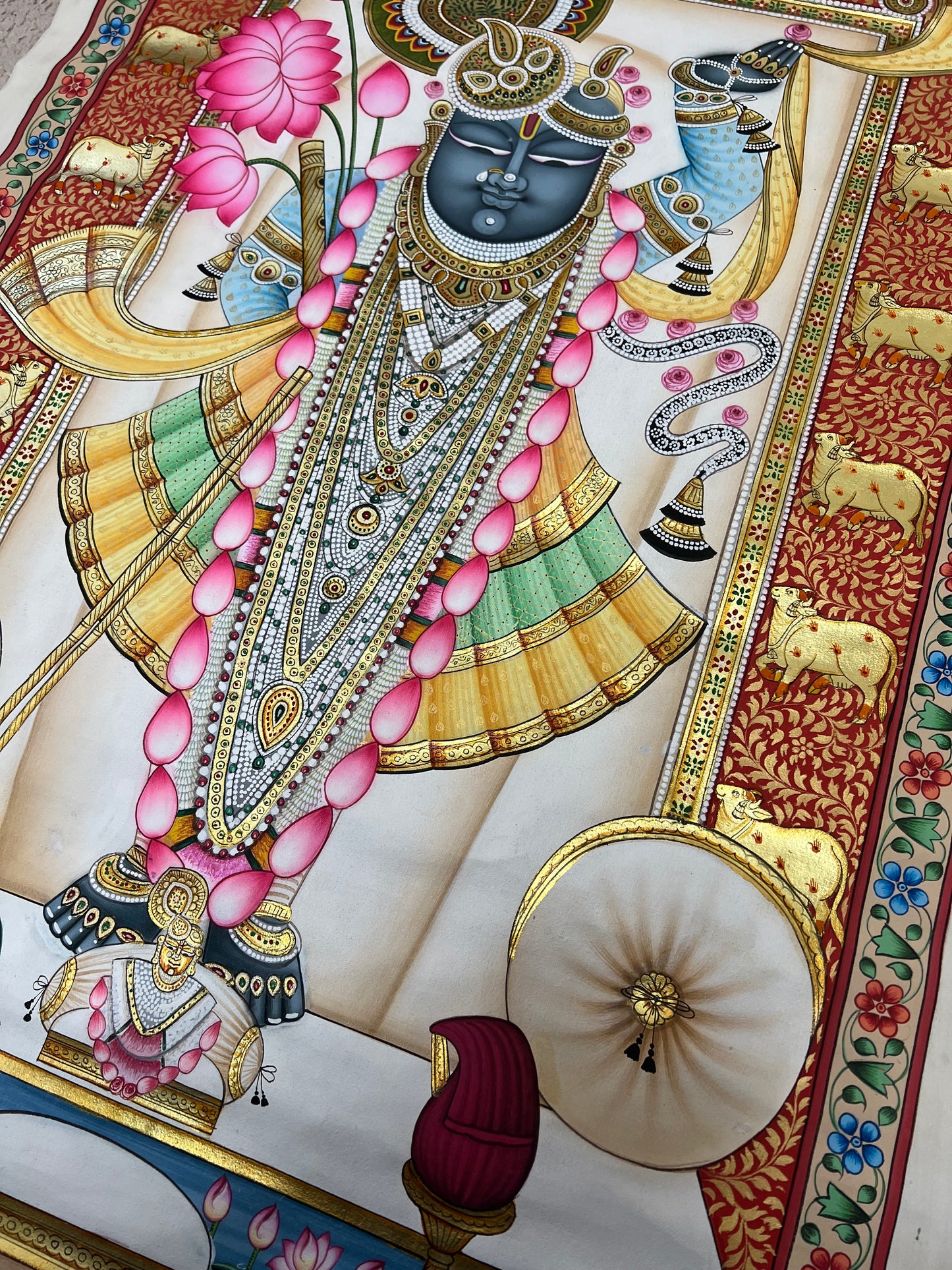 Close-up of Shreenathji Pichwai artwork showing gold leaf detailing and intricate brushwork