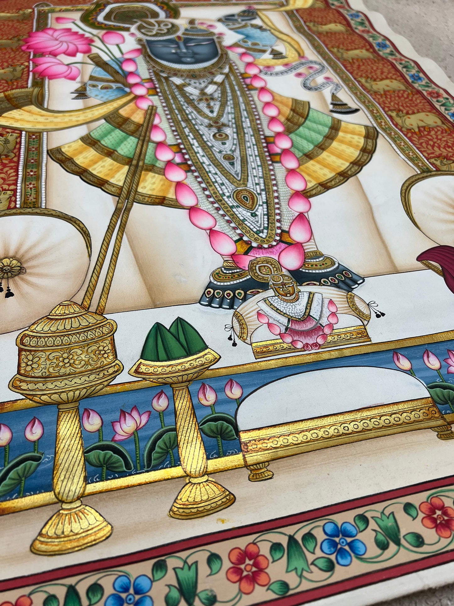 Close-up of Shreenathji Pichwai artwork showing gold leaf detailing and intricate brushwork