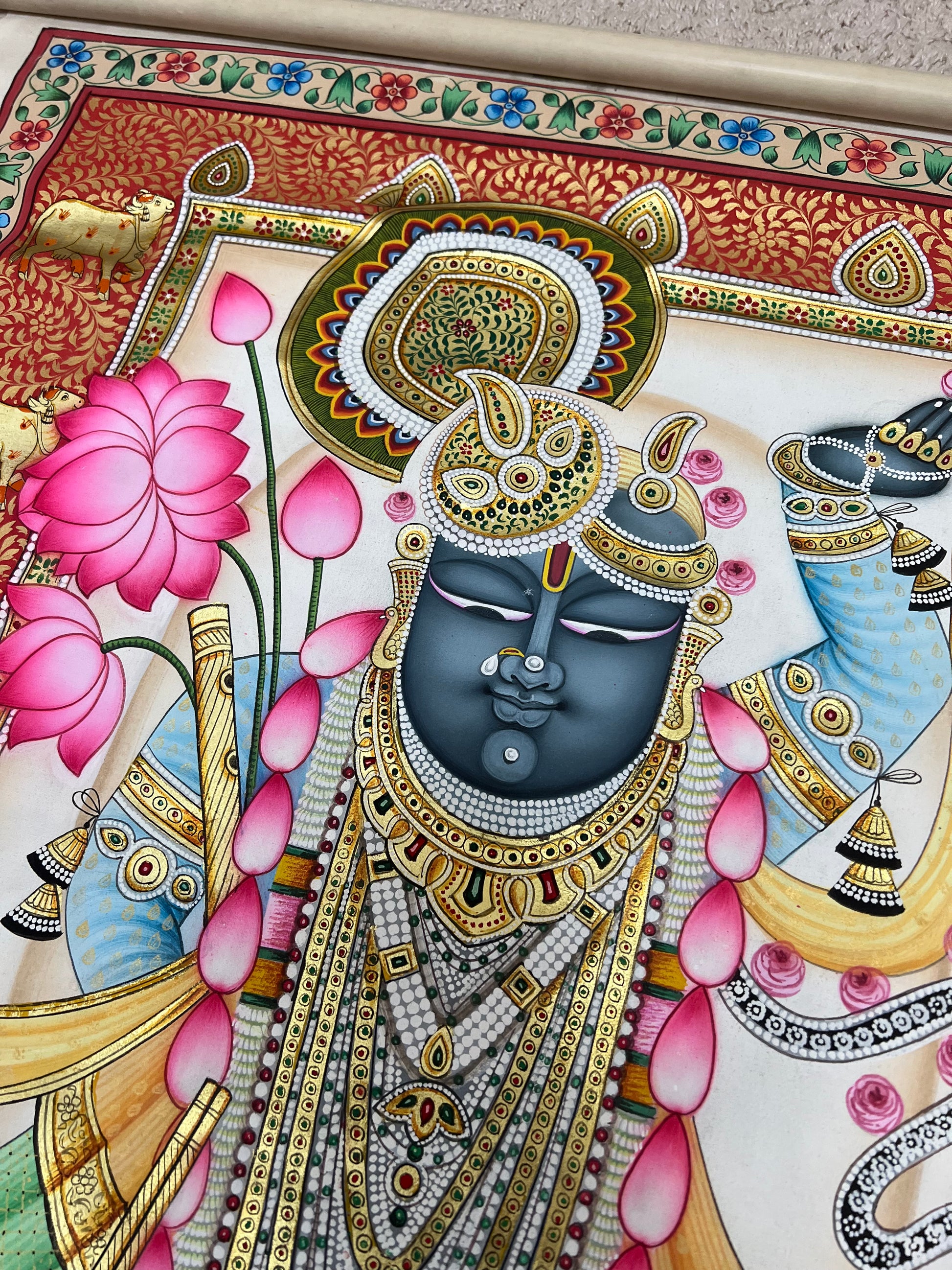 Close-up of Shreenathji Pichwai artwork showing gold leaf detailing and intricate brushwork